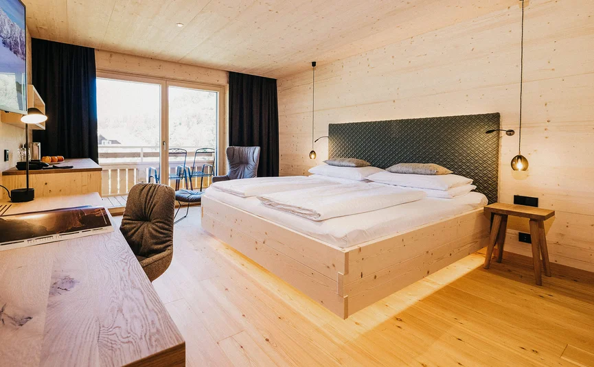 Modern hotel room with wood design and balcony overlooking mountains
