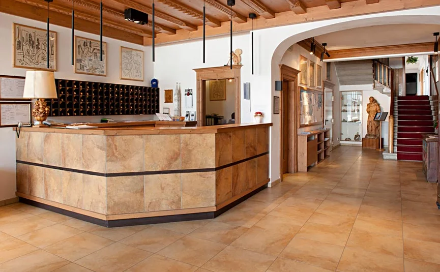 Empfangsbereich mit Rezeption und Treppe in einem hellen Raum