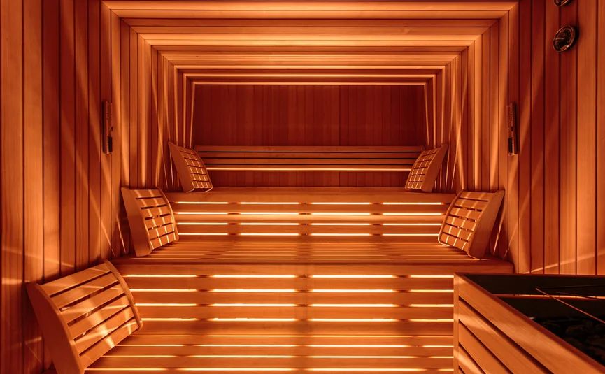 Leere Holzsauna mit warmem Licht und Kopfstützen
