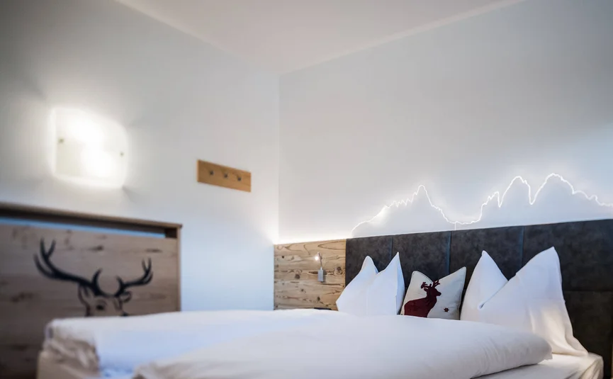Modern bedroom with deer decor and illuminated headboard wall design