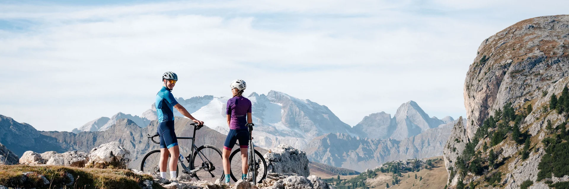 Zwei Radfahrer mit Helm in den Bergen auf einem felsigen Pfad