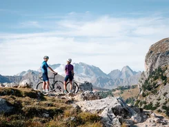 Two cyclists with helmets on a rocky mountain trail