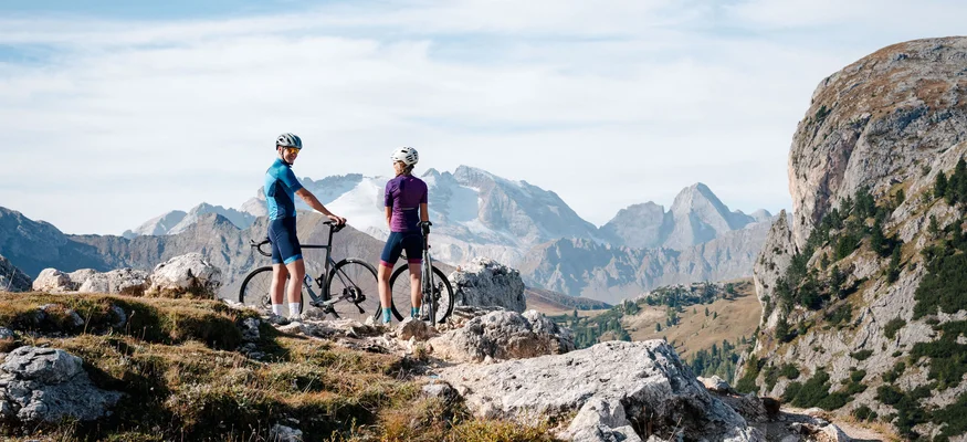 Zwei Radfahrer mit Helm in den Bergen auf einem felsigen Pfad
