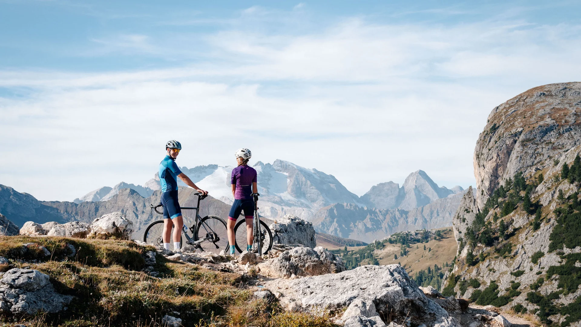Zwei Radfahrer mit Helm in den Bergen auf einem felsigen Pfad