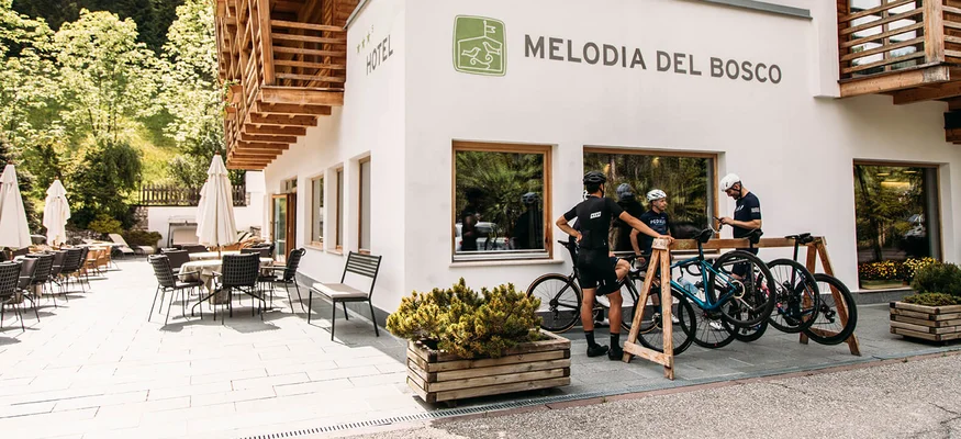 Gravelbiken ist eine Welt zwischendrin. © Chiara Redaschi Hotel Melodia del Bosco mit Außenbereich und Radfahrern vor dem Eingang