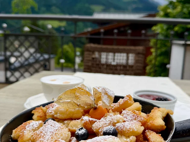 5 Gravel-Touren in der Salzburger Sportwelt, die du kennen solltest © Daniela Erner Kaiserschmarrn mit Puderzucker und Beeren in Pfanne auf Bergterrasse