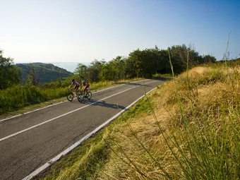 Marche © Heiko Mandl Two cyclists riding on a road through green landscape on a sunny day