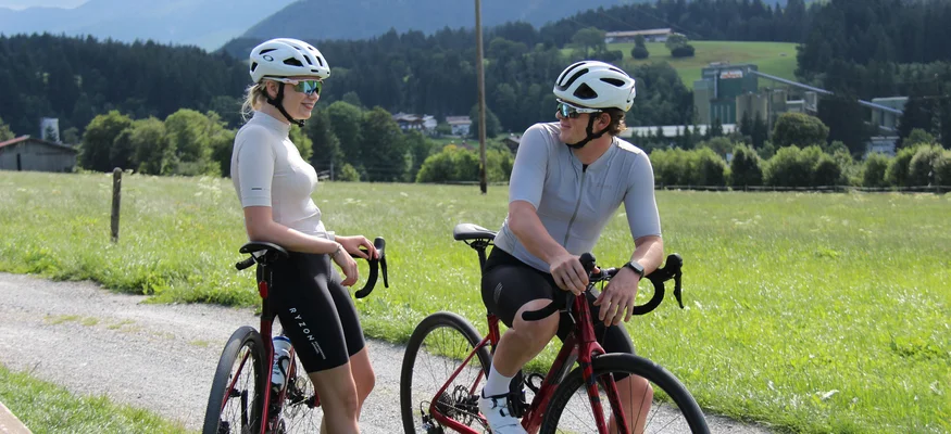 Zwei Radfahrer mit Helmen auf ihrem Fahrrädern an einem ländlichen Weg