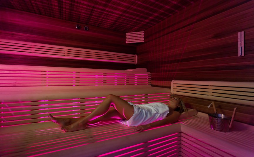 Triathlon & Rennrad Aktivhotel SantaLucia **** © Fabio Staropoli Frau entspannt in moderner Sauna mit rosa Beleuchtung