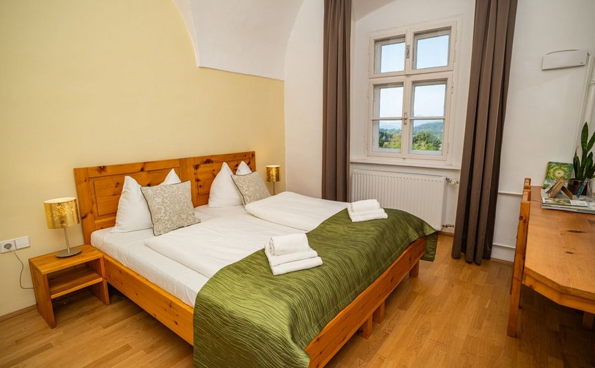 Stift St. Georgen **** © Arnold Pöschl Gemütliches Doppelzimmer mit Holzmöbeln und Blick ins Grüne