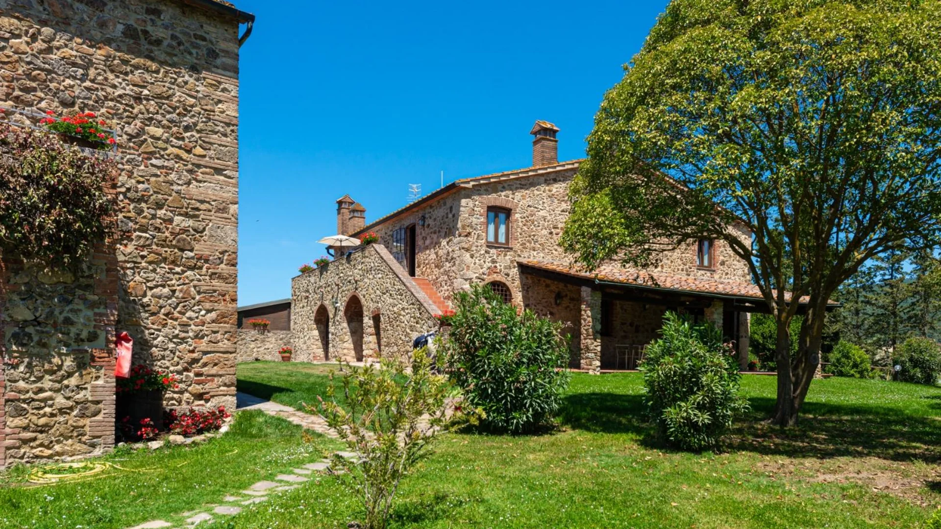 Gravelbiken in der Toskana © Tenuta il Cicalino Steinbauernhaus mit Garten und Baum bei klarem Himmel