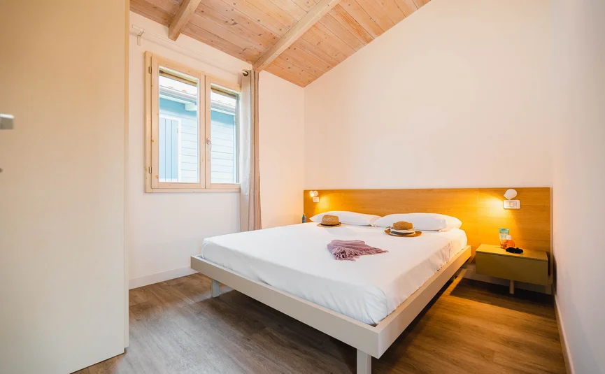 Bright bedroom with modern bed and wooden beam ceiling