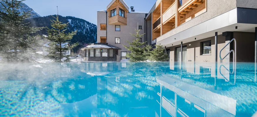 Beheizter Außenpool vor Berghotel im Winter