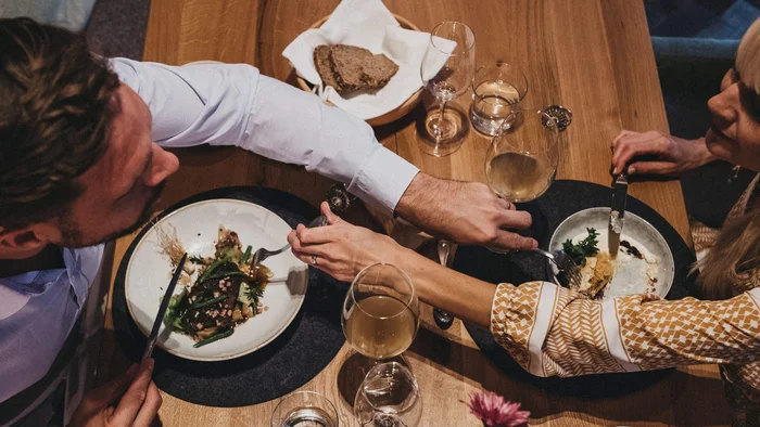 Paar beim Abendessen, das sich Essen vom Teller teilt