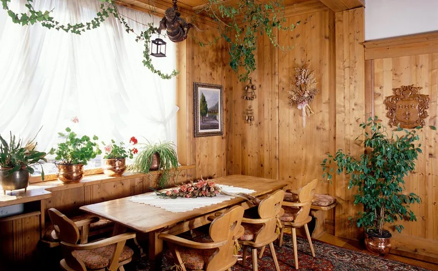 Gemütlicher Holzesstisch mit Stühlen und Pflanzen in einem traditionellen Raum