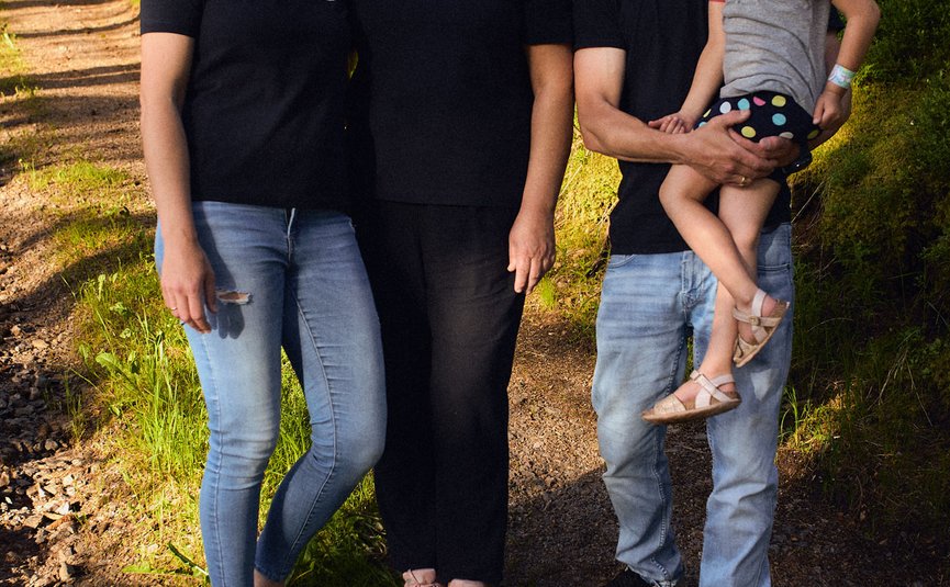 Familie mit zwei Frauen, Mann und Kind im Wald auf Wanderweg