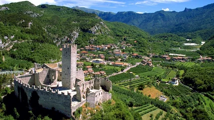 Castle on hill with green valley and village in the background