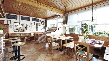 Am Krumbacherhof biked der Wirt! © Wiener Alpen Croy Gemütliches Café mit Holzmöbeln und großen Fenstern