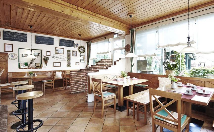 Gemütliches Café mit Holzmöbeln und großen Fenstern