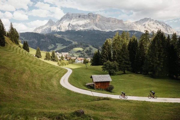 5 Gravelbike-Touren in Alta Badia, die du gefahren haben solltest © Alex Moling Zwei Radfahrer auf einem Weg im grünen Tal mit Bergen im Hintergrund