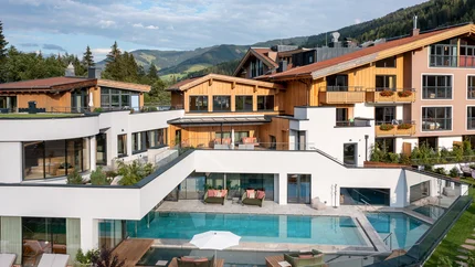 Modernes Hotel mit Außenpool und Bergblick bei klarem Himmel