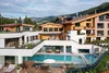 Modern hotel with outdoor pool and mountain view under clear sky