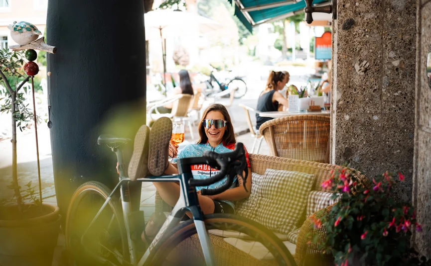 Bike Boutique Hotel Lindenhof **** © Martin Hofmann Frau entspannt mit Fahrrad und Getränk auf Caféterrasse