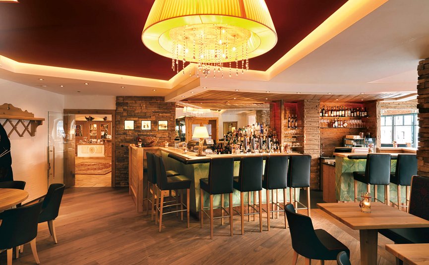 Gemütliche Bar mit Holzmöbeln und großer Deckenlampe