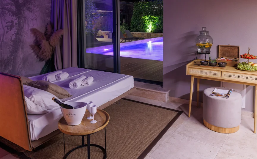 Cozy room with bed and view of illuminated pool at night