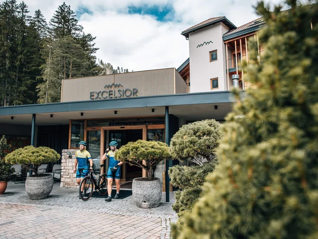 Zwei Radfahrer verlassen das Hotel Excelsior im Wald