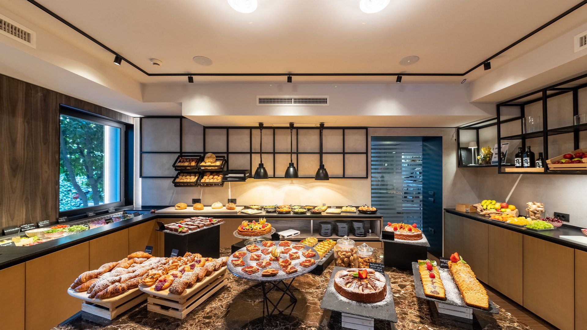 Buffet mit Gebäck, Kuchen und Obst in modernem Frühstücksraum