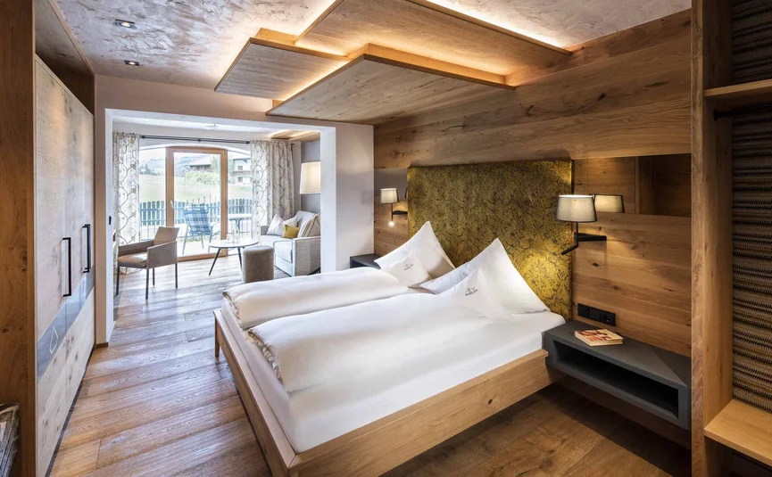 Modern hotel room with double bed and seating area overlooking outside