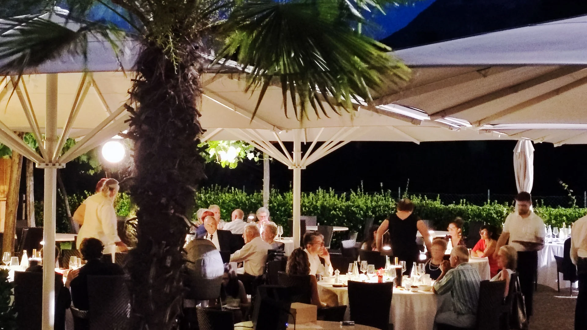 Auf Schotterkurs im Hotel Teutschhaus © Ingrid Heiss Anderen beim Abendessen im Außenrestaurant unter beleuchteten Sonnenschirmen zuschauen