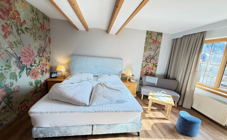 Bike Boutique Hotel Lindenhof **** © Martin Hofmann Helles Schlafzimmer mit Doppelbett, Blumenwand und Sitzbereich mit Sofa
