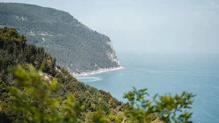Küste mit bewaldeten Hügeln und Blick auf das blaue Meer