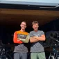 Zwei Männer vor einem Fahrradladen mit Mountainbikes im Hintergrund