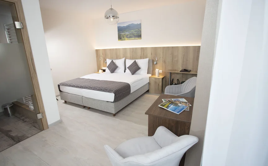 Modern hotel room with double bed and seating area