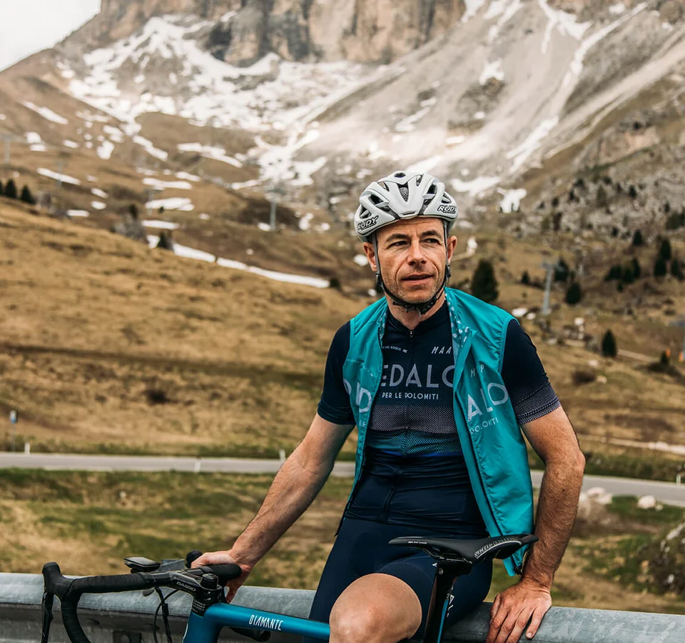 Gravelbiken ist eine Welt zwischendrin. © Chiara Redaschi Rennradfahrer mit Helm vor Berglandschaft mit wenig Schnee