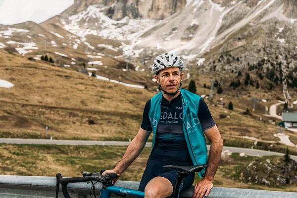 5 Gravelbike-Touren in Alta Badia, die du gefahren haben solltest © Chiara Redaschi Rennradfahrer mit Helm vor Berglandschaft mit wenig Schnee