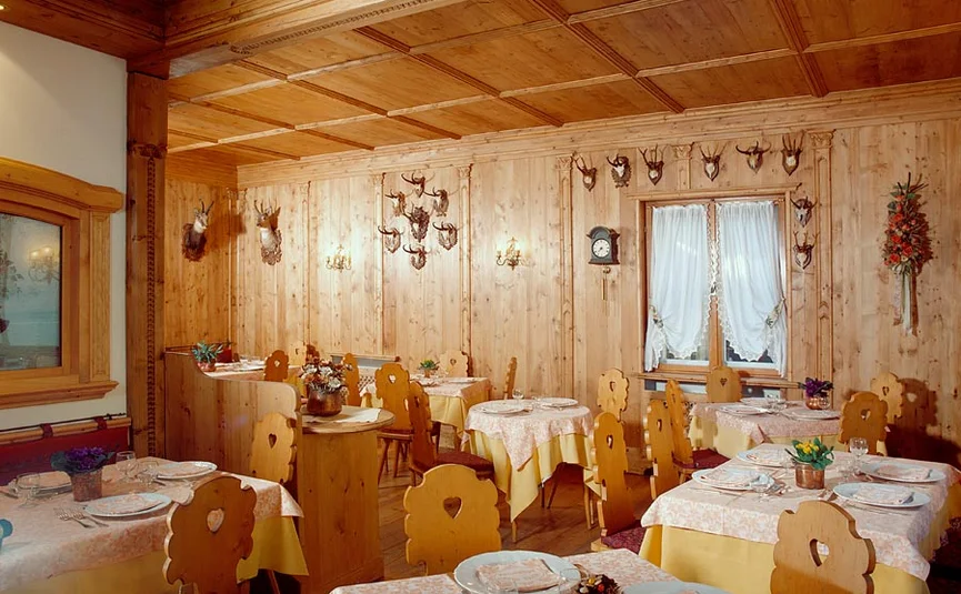 Traditionelles Restaurant mit Holzvertäfelung und Hirschgeweihen an der Wand