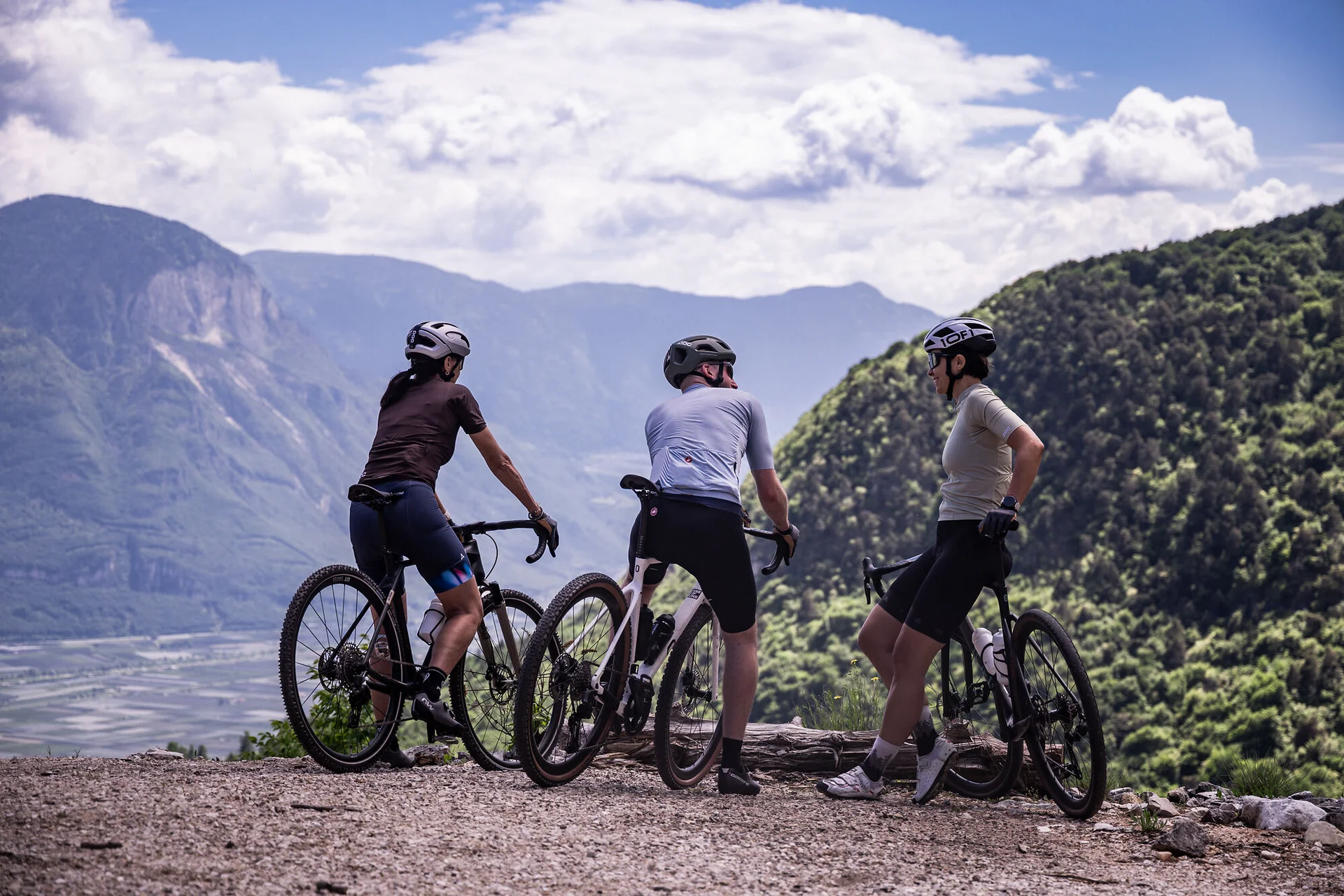 Drei Radfahrer genießen die Aussicht in den Bergen bei klarem Himmel