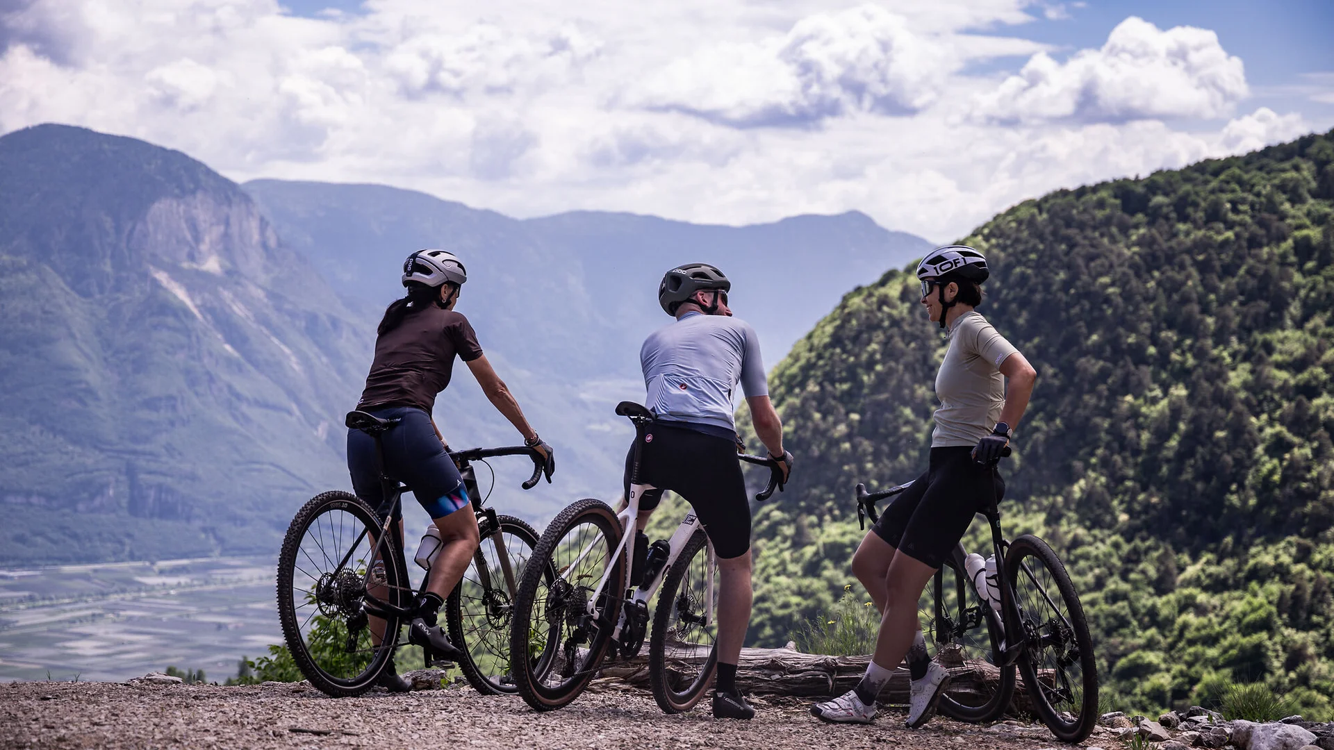 Drei Radfahrer genießen die Aussicht in den Bergen bei klarem Himmel