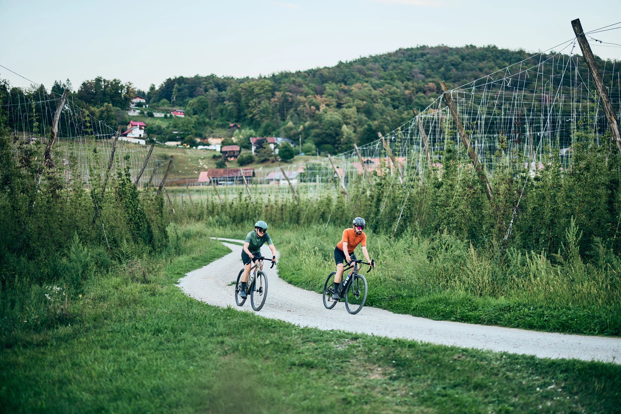 Slovenia © Tobias Köhler Two cyclists riding on a gravel path in a green rural landscape.
