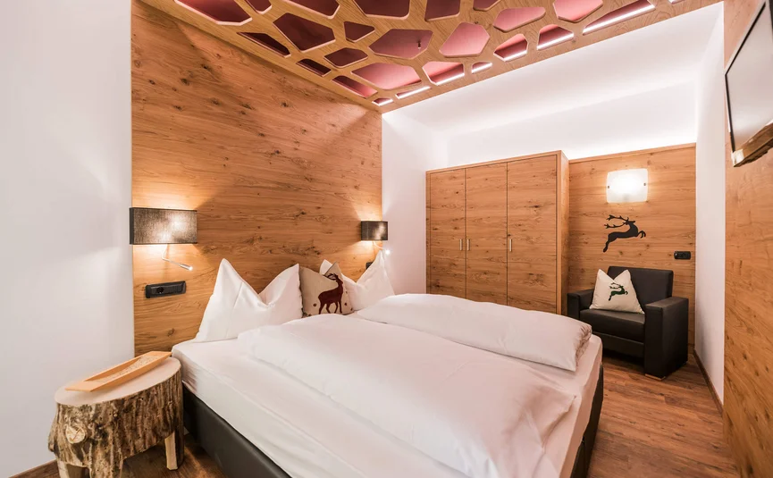 Cozy bedroom with wood decor and deer motifs on pillows and wall