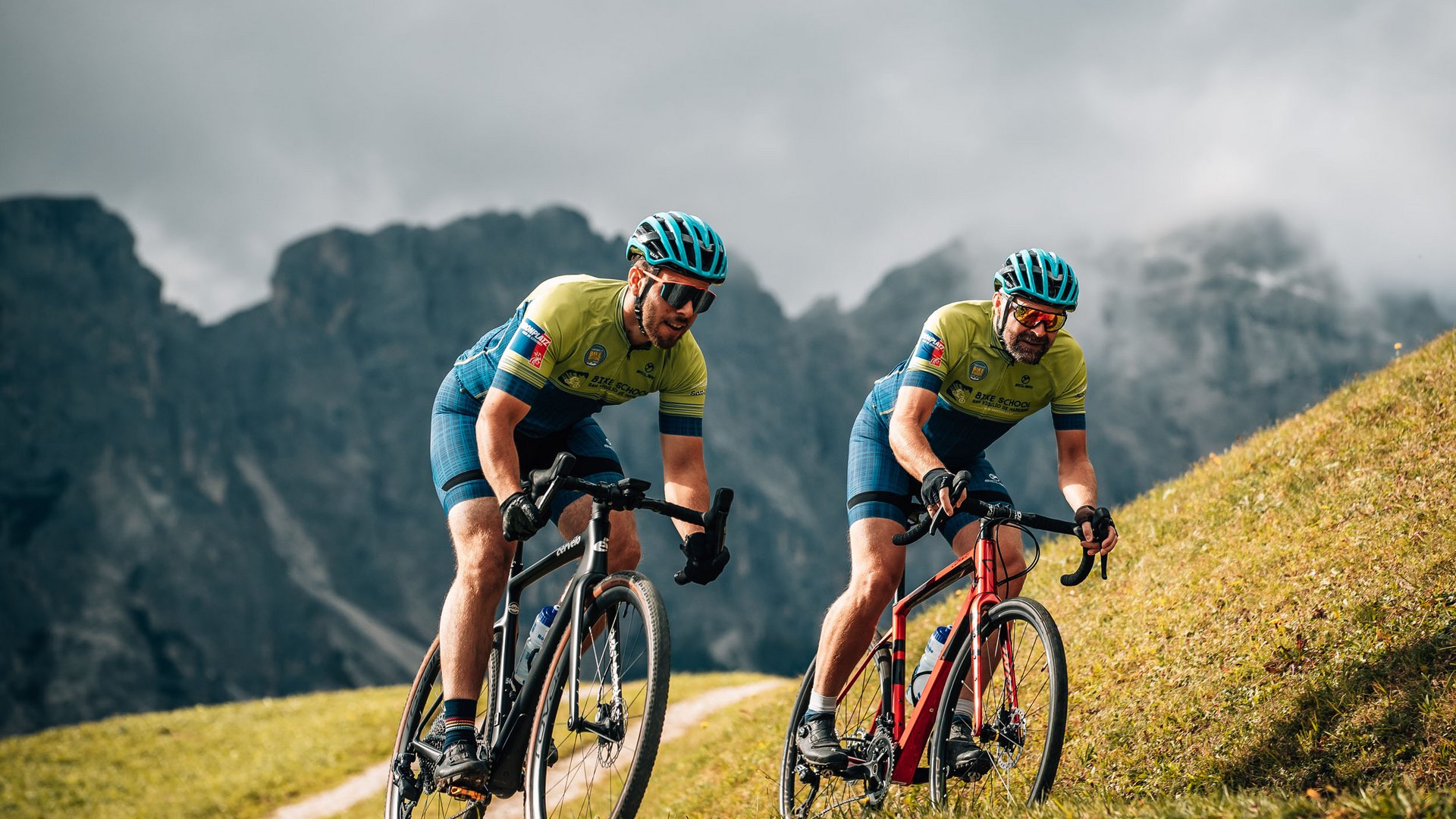 Zwei Radfahrer in Helmen fahren einen Bergweg in den Bergen hinauf