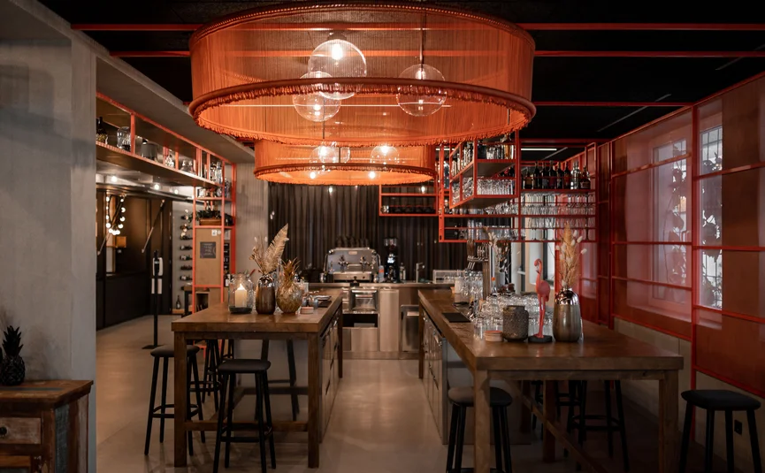 Modern bar interior with wooden counters and orange lampshades