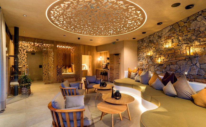 Gemütlicher Lounge-Bereich mit modernem Holz- und Steindekor und indirekter Beleuchtung
