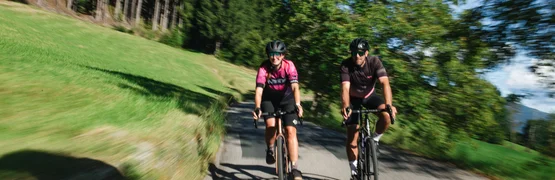 Gravel Badges Festival – 3 days of cycling and that autumnal feeling © Nicola Littmann Two cyclists riding on a country road with trees and grass around