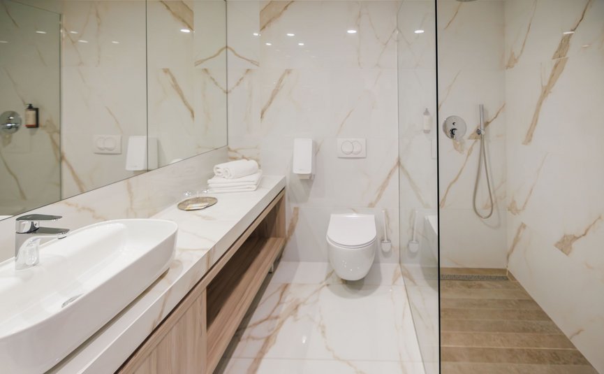 Modernes weißes Badezimmer mit Waschbecken, Toilette und begehbarer Dusche