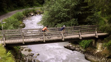 Graveltour Silbertal © Janine Brugger - Vorarlberg Tourismus Zwei Radfahrer fahren über eine Holzbrücke über einen Fluss in einem Wald